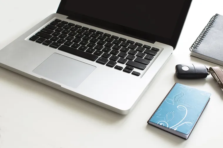 Laptop, smartphone and notebook on a desk, ready to compare crypto exchanges