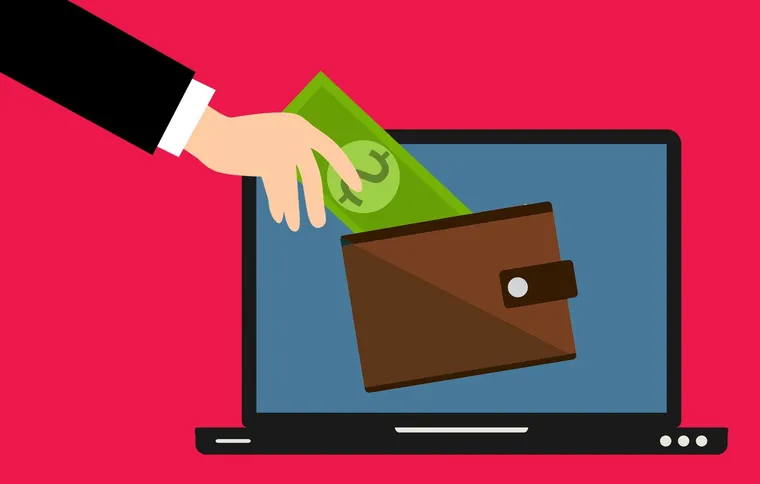 A hand placing banknotes into a wallet shown on a laptop screen, illustrating an online crypto account